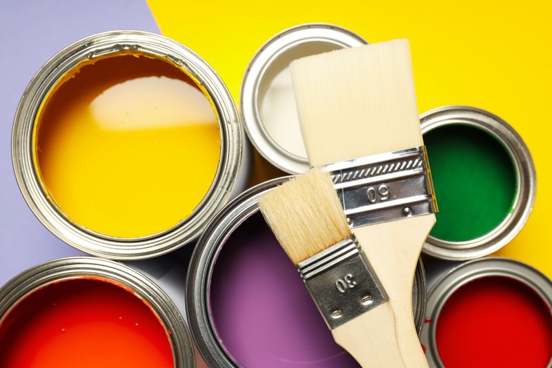 Botes de pintura de colores y brochas