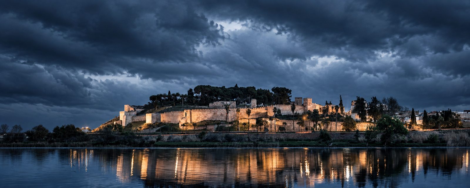 Alcazaba de Badajoz iluminada bajo un cielo de tormenta