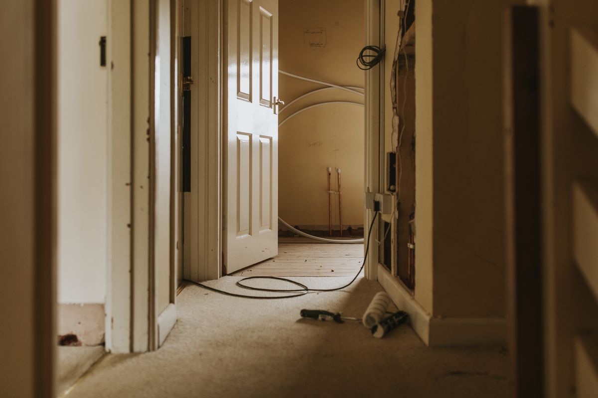 Pasillo de una vivienda en reforma con puertas de madera abiertas